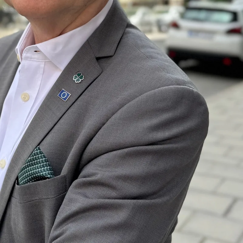 Centerpartiets nål och EU-flaggan på samma kavajslag.